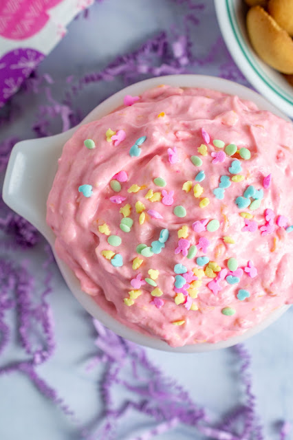 pink dip with easter sprinkles in a white bowl with purple confetti background.