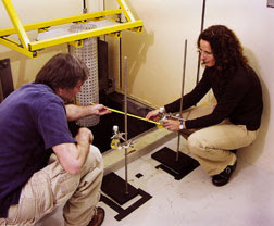 Jason Jones and Tina Nenoff set up an experiment in a testing cell at the Gamma Irradiation Facility. (Photo by Randy Montoya)