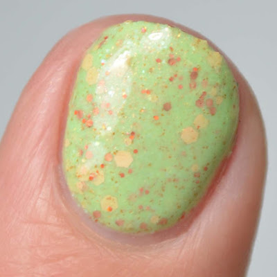 green nail polish with warm toned glitters swatch