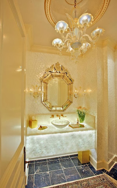 beautiful glowing powder room with stunning chandelier, floating vanity and elegant mirror by RSVP Design