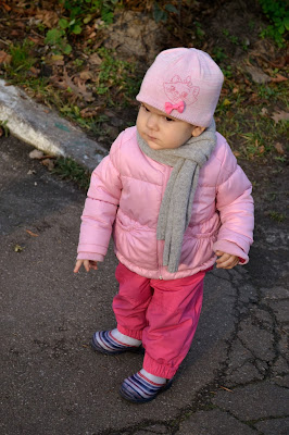 маленькая девочка гуляет на улице, на свежем воздухе, в теплой одежде, осенью