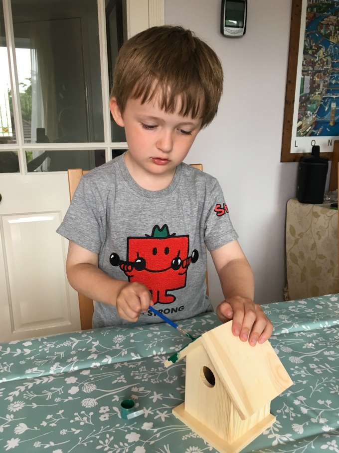 BoxWild-Children's-Big-Bird-Gift-Box-Review-boy-concentrating-and-painting-roof-green