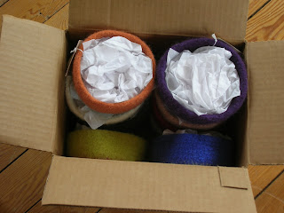 cardboard box full of felted bowls