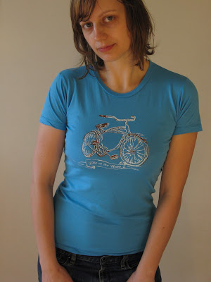 A portrait of Aramee Diethelm wearing a tshirt that she designed and silkscreened.