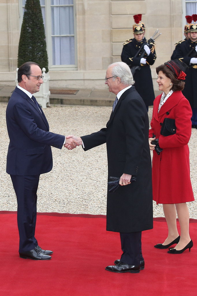 French President Francois Hollande (C) delivers a speech as Swedish King Carl XVI Gustaf (L) and Queen Silvia (R) listen during a state dinner at the Elysee presidential palace in Paris