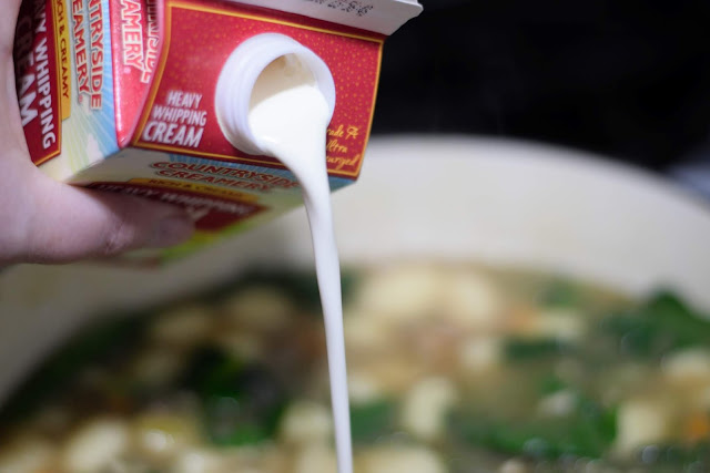 Heavy cream being added to the soup