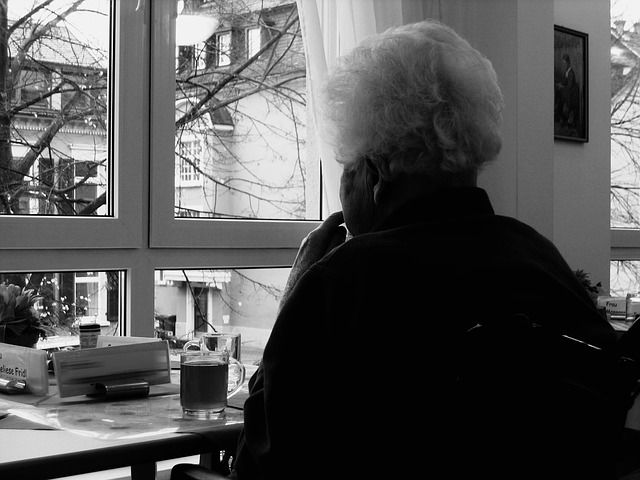 Donna anziana sola guarda fuori