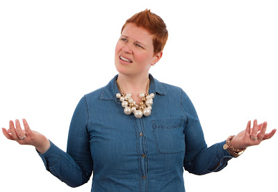 A woman with brown hair wearing necklace seems confused