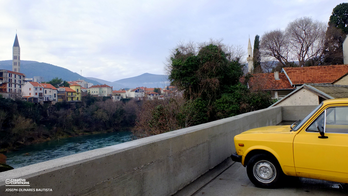 An old yellow Lada parked overlooking the Neretva River. Mostar, Bosnia and Herzegovina. / Photo by: Joseph Bautista. A free travel stock photo licensed under Creative Commons.