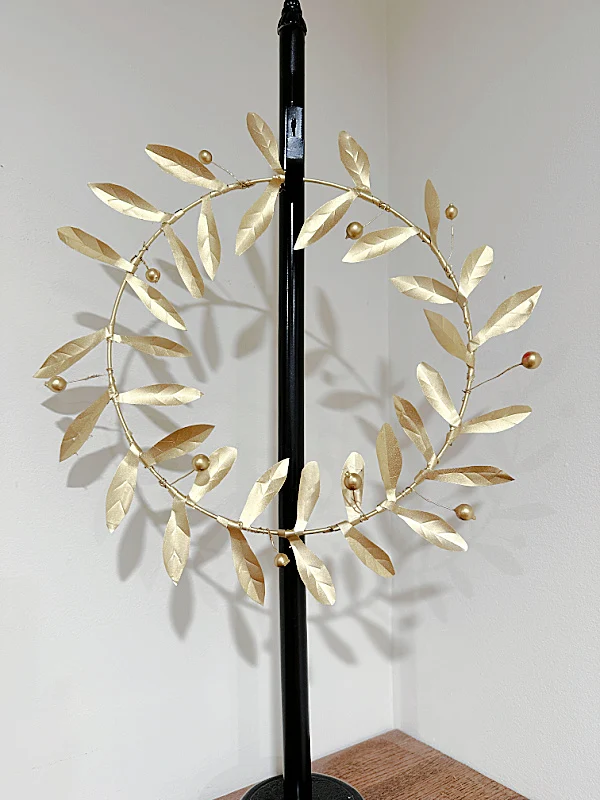 gold metal wreath on wreath stand