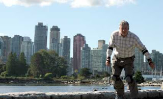 Wolfgang Fabisch auf Inlinern im Stanley Park vor der Skyline Vancouvers