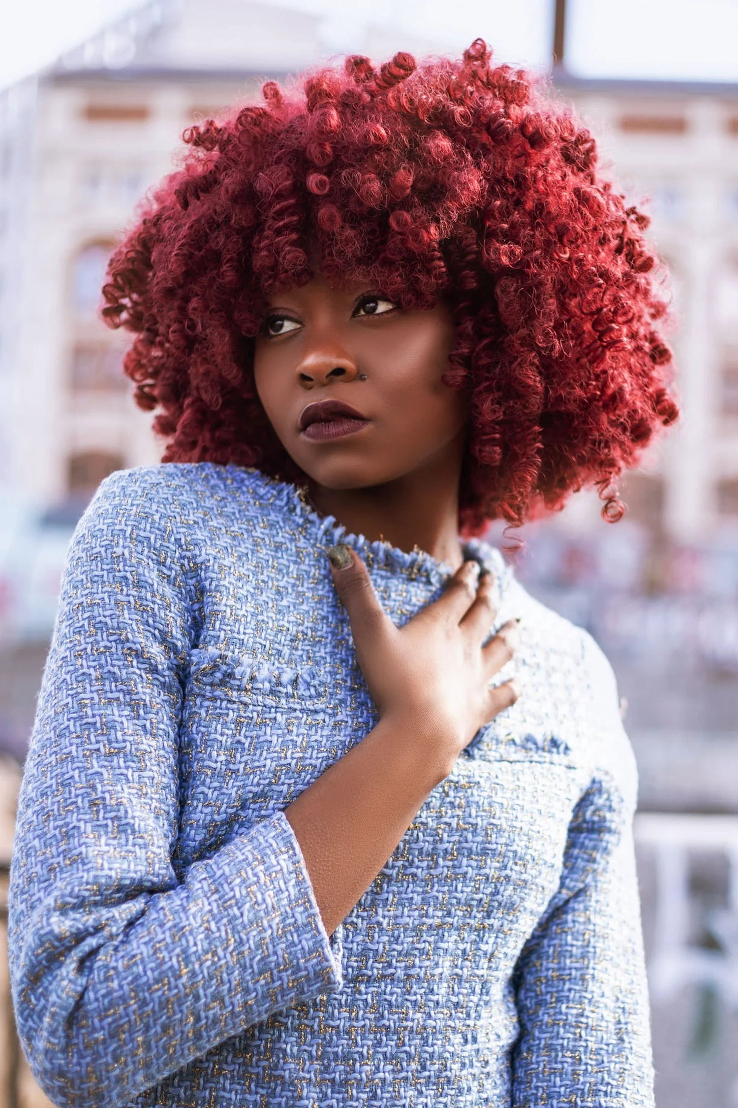 beautiful woman in chanel suit with red afro hairstyle