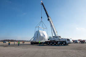 The Orion spacecraft being lifted onto the truck for transport to NASA's Plum Brook Station