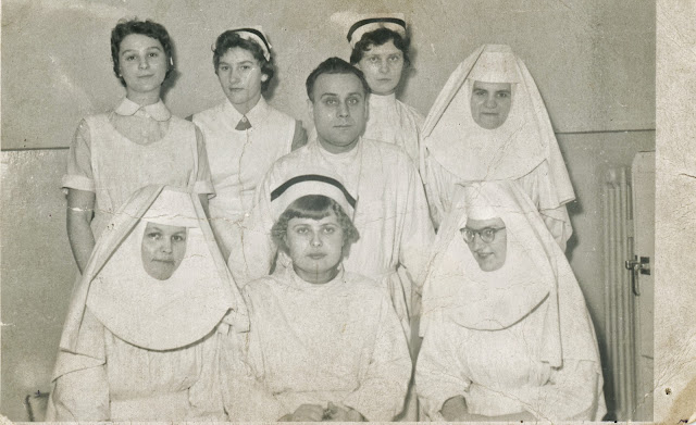 Verpleegsters en nonnen rond man in witte badjas. Collectie Robert van der Kroft