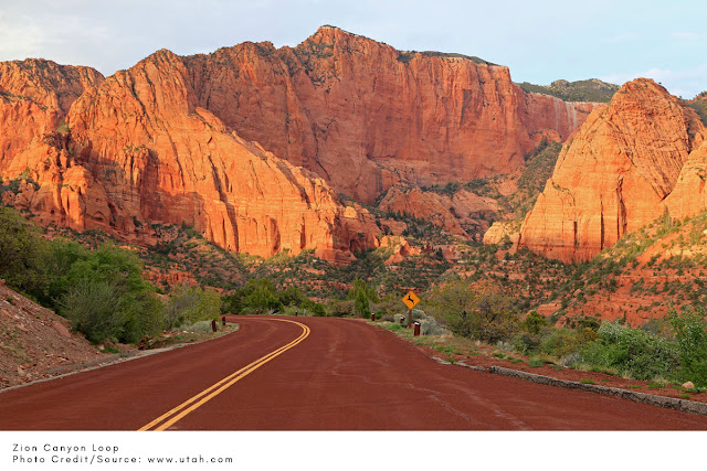 red road winding through tall red rocks