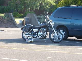 A Honda Rebel sits in a parking space next to a van