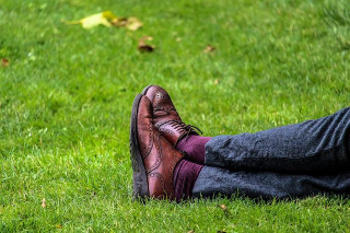 A Man Sitting on Grass Wearing a Pair of Leather Oxford Shoes