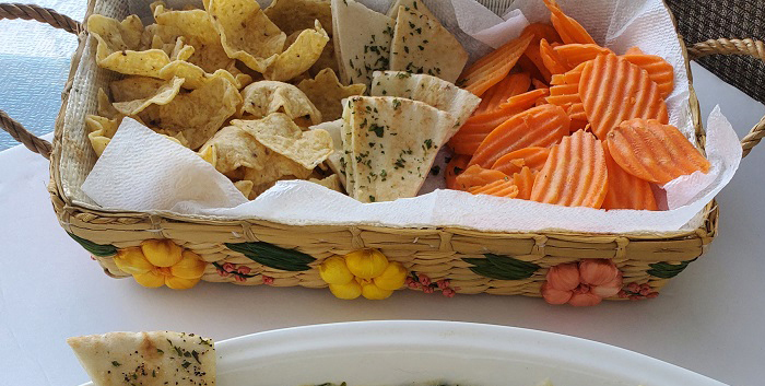 assorted ingredients for hummus dip pita points, crackers, tortilla chips