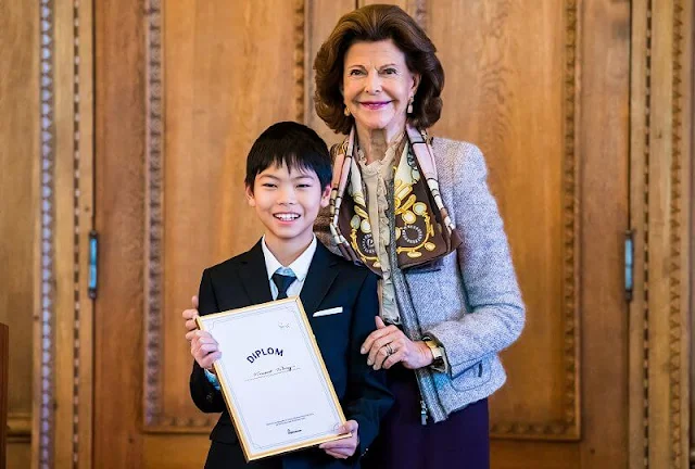 Queen Silvia wore a grey tweed jacket by Chanel. Beige ruffled silk blouse. Versace atelier silk scarf. Vincent Wang and Iris Forssberg