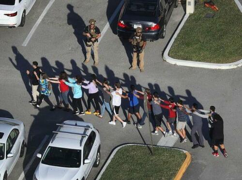 People are brought out of the Marjory Stoneman Douglas High School after a shooting at the school left 17 people dead on February 14, 2018 in Parkland, Florida