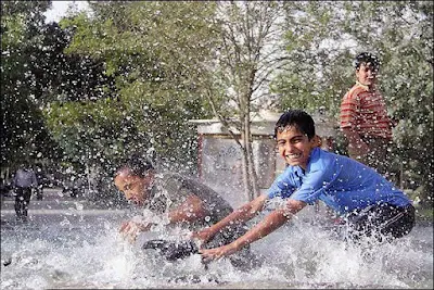 Kids pouring water on each other, Water Festival in Iran