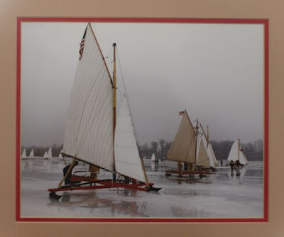 Iceboats lined up to race on a frozen lake.