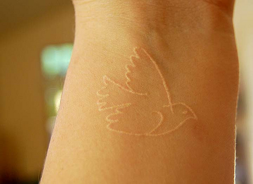 dove tattoo on wrist made using by white ink tattoo