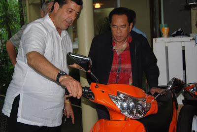 Dave Dewbre explaining the Chavit how to operate the electric, and extremely energy efficient motor bike.