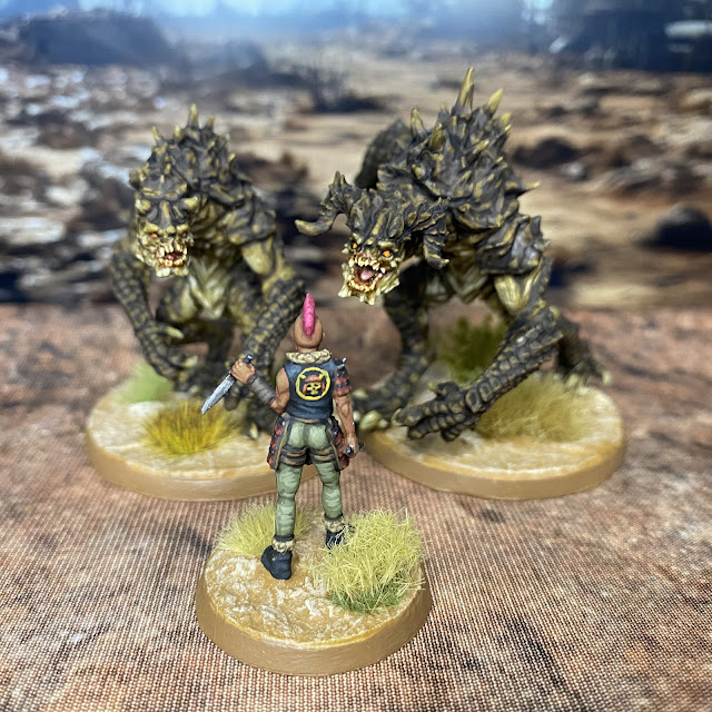 32mm post-apocalypse  miniatures from Vermillion and TennageWastelandUS  that are compatible with Fallout Warfare Wasteland.  Red Rock Raider (Great Khan) versus Deathclaws