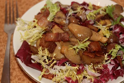 Serving plate of warm mushroom, chestnut, and bacon salad.