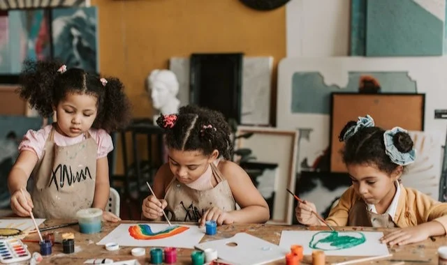 ثلاثة أطفال في فصل الفنون للاطفال تعليم الرسم والفنون