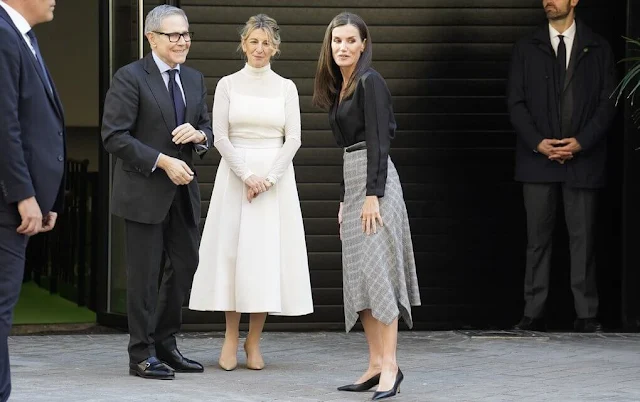 Queen Letizia wore a grey pointed check wool skirt by Massimo Dutti, and a black v-neck silk shirt by Sandro Paris