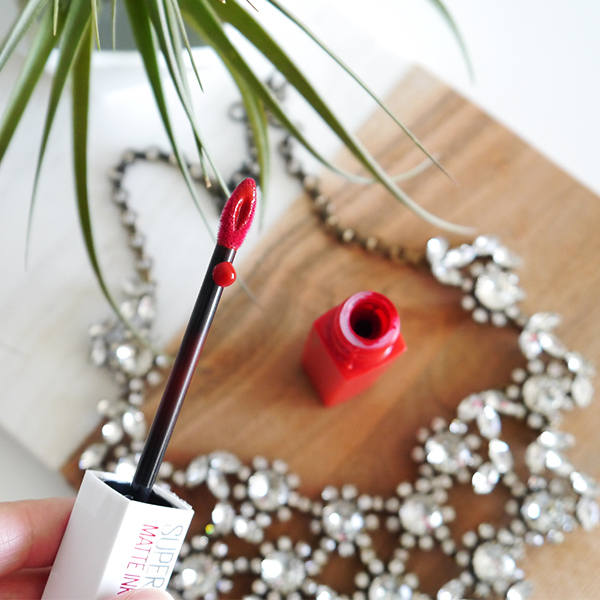 Detail shot of the teardrop-shaped applicator with reservoir tip on Maybelline Super Stay Matte Ink lipstick in classic red 'Pioneer'