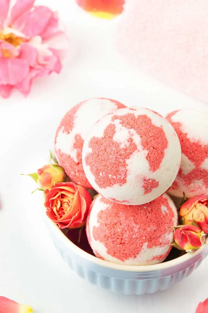 How to make a strawberry milkshake bath bomb without cornstarch. These cute and unique bath bombs would make a great gift. These natural bath bombs are fizzy and moisturizing. This DIY easy recipes uses essential oils for natural scents.  Home made pretty and cool bath bombs.  If you need ideas for summer bath bombs, try this recipe.  #bathbomb #diy #strawberry