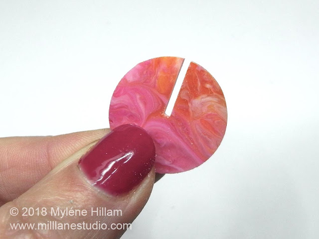 The cured, marbled resin circle with a slit cut into it. 