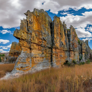 Panoramic landscape of Isalo National Park, Madagascar, featuring dramatic rock formations, canyons, and sparse vegetation.