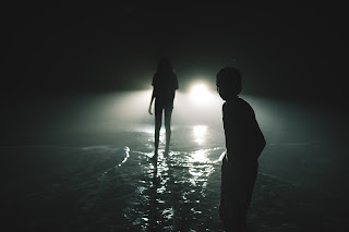 Photo of two alien figures in the dark