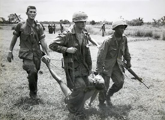 Vietnam War ca 1965 US soldiers carrying a VietCong victim