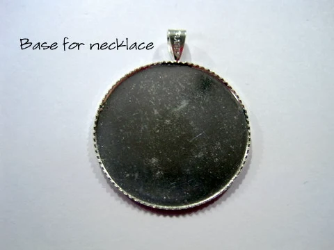 Silver coloured cabochon ready to be finished into a cross stitch necklace