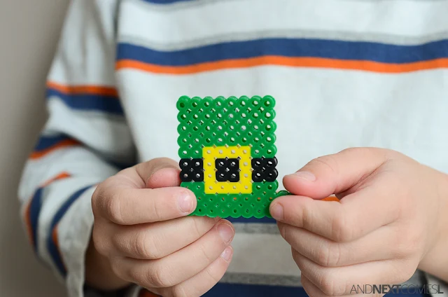 Child holding a leprechaun hat perler bead project