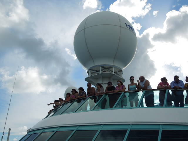 people on top deck watching sailaway