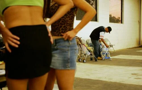 A man stands near two women posing as prostitutes during a police sting in Pomona, Calif., on Nov. 12, 2004. (David McNew/Getty Images)