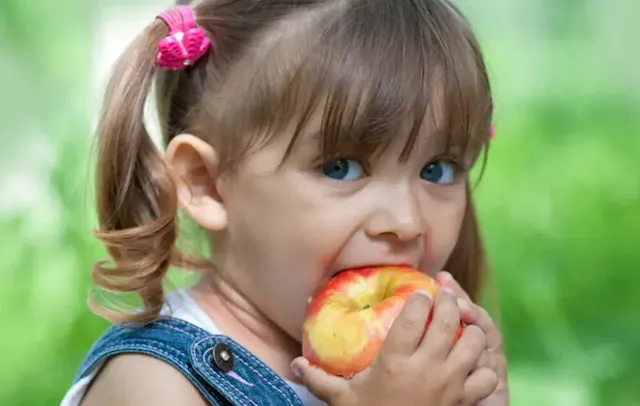 A kid eating an apple