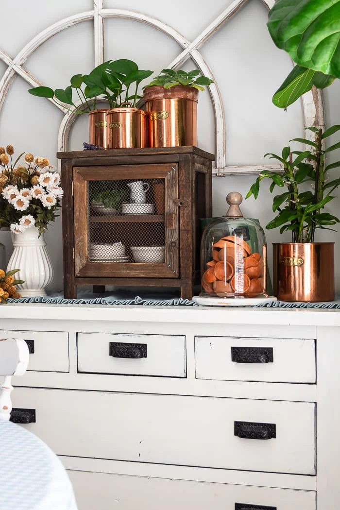 white dresser, copper, pie safe, terracotta in glass cloche, fall florals