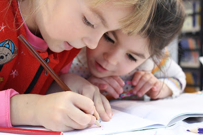 2 children writing at a desk - buddy blog ideas
