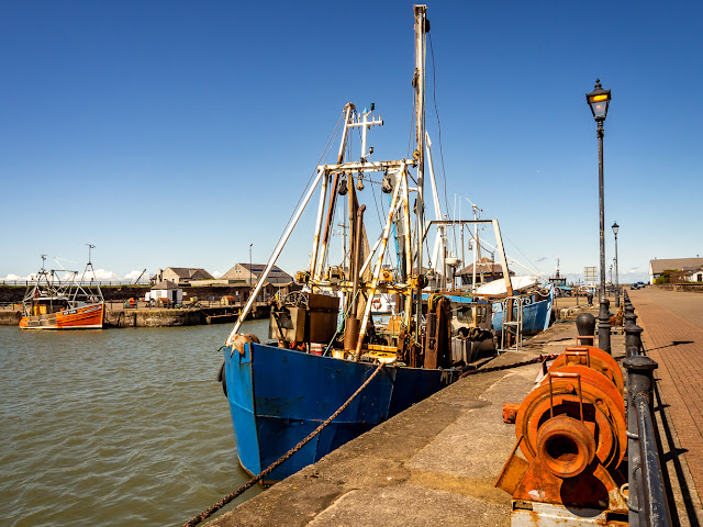 Photo of a fishing boat and rusty trawler winch at Maryport Harbour