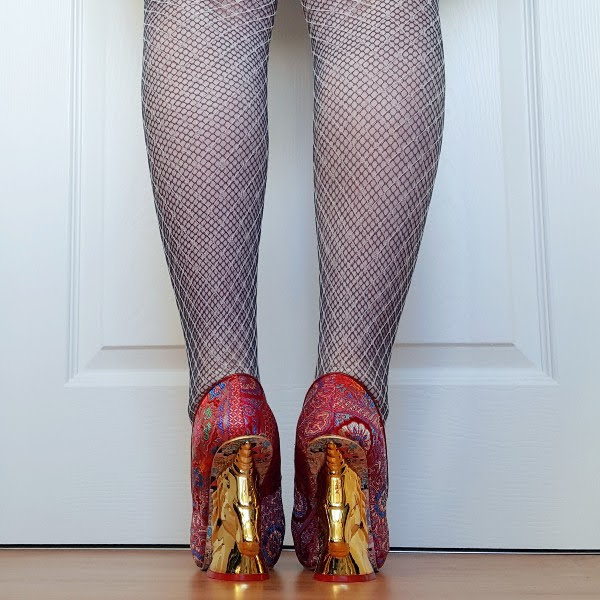 back of legs in layered fishnet tights with gold unicorn heel shoes