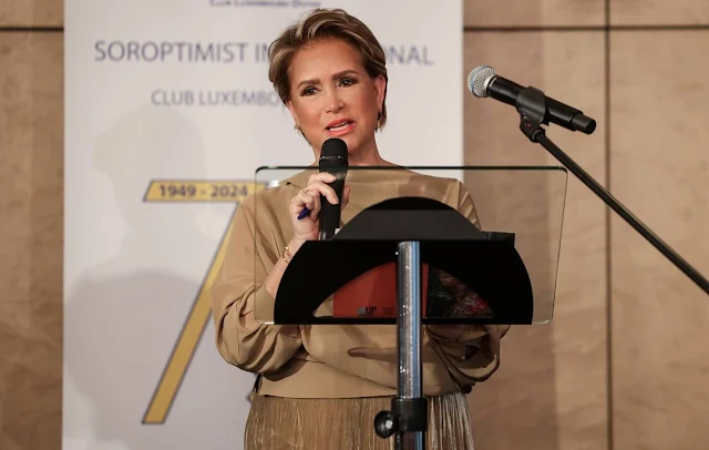 Grand Duchess Maria Teresa wore a cold beige double-breasted trench jacket by Acne Studios. Soroptimist Luxembourg-Doyen club