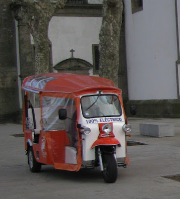 tuk tuk laranja e branco com escrito 100% elétrico