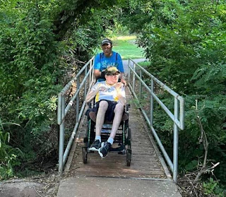 me pushing Chris across a bridge at Yukon's boot park